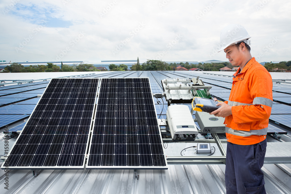 工程师维护工厂屋顶上的太阳能电池板设备