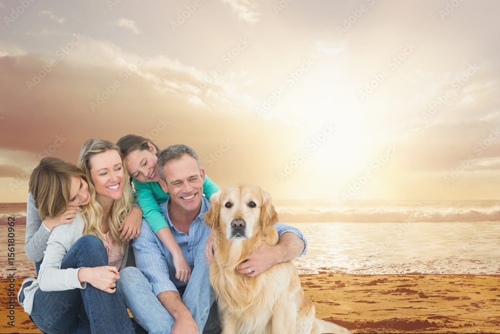 带着狗在海滩上微笑的一家人