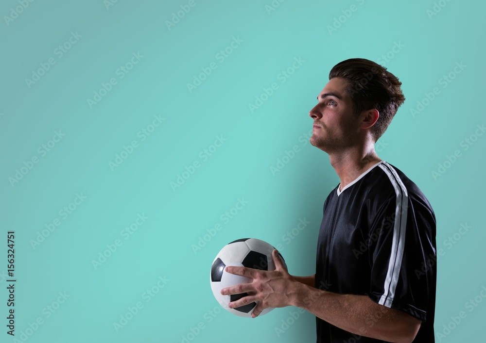 足球运动员手拿球抬头看。蓝色背景