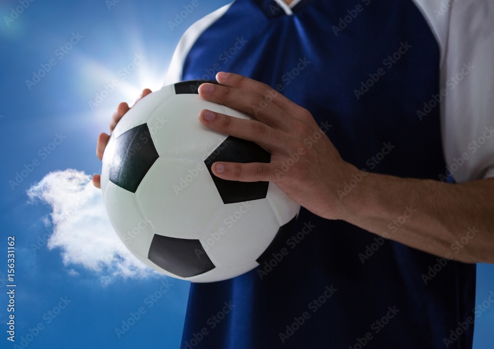 手上拿着球、天空湛蓝的足球运动员