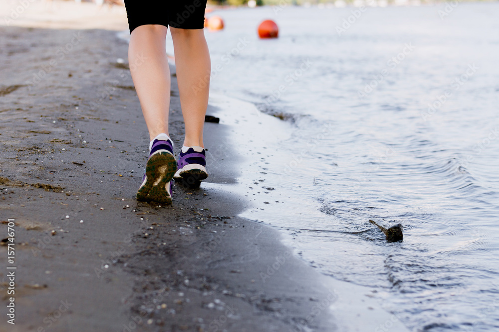 在海滩上健身和跑步，女跑步者在海边的沙滩上穿鞋