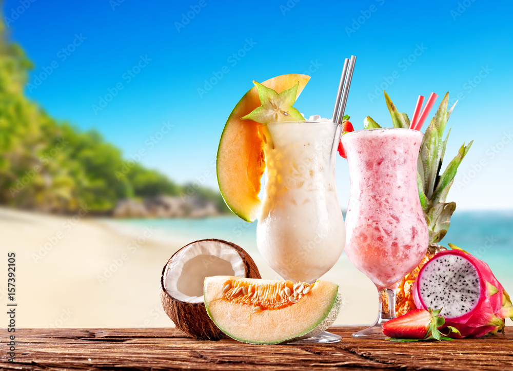 Fresh fruit drinks placed on wooden planks, blur beach on background