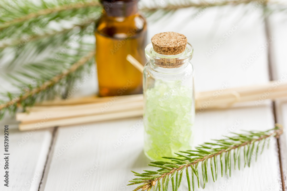 spa with organic spruce oil and sea salt in glass bottles on white table background