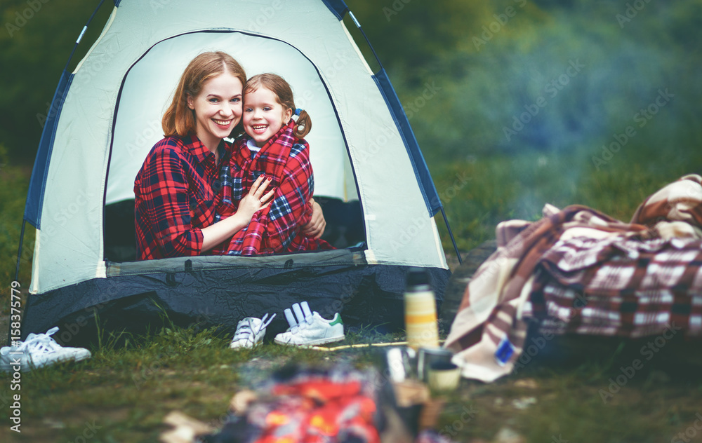 家庭母女带着帐篷在露营旅行中喝茶