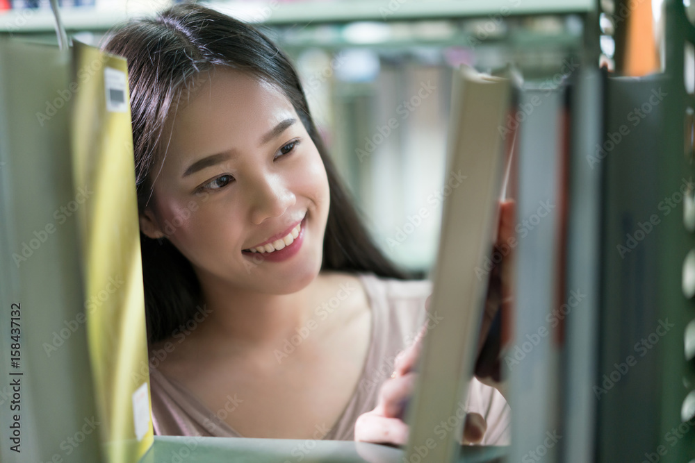 亚洲女学生书籍从书架上挑选