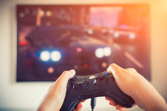 Player playing console car race videogame holding gamepad