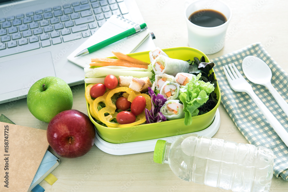 Close up the green Lunch box on work place of working desk ,Healthy eating clean food habits for die
