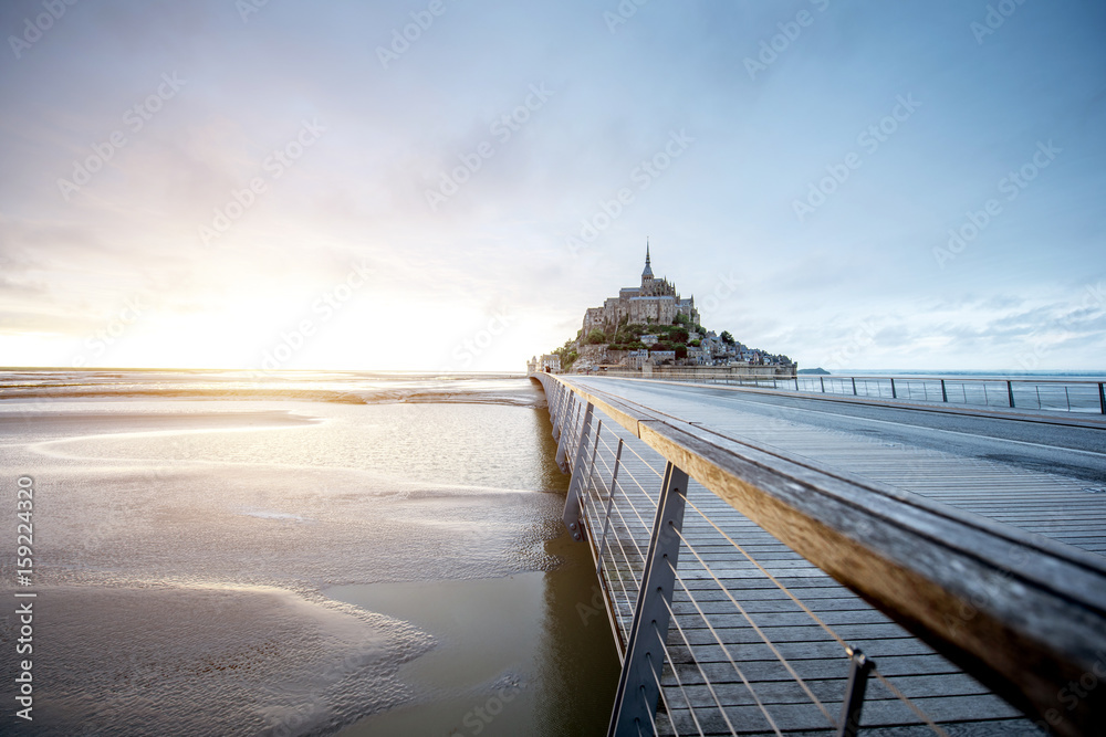 法国著名的圣米歇尔山修道院的日落景观，潮汐期间有桥