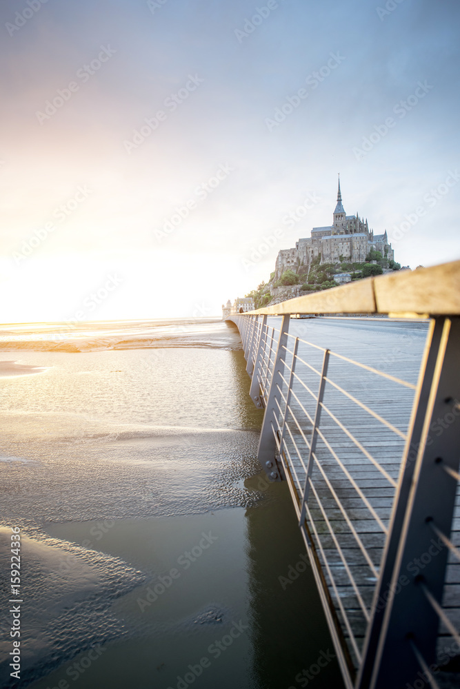 法国著名的圣米歇尔山修道院日落景观，潮汐期间有桥