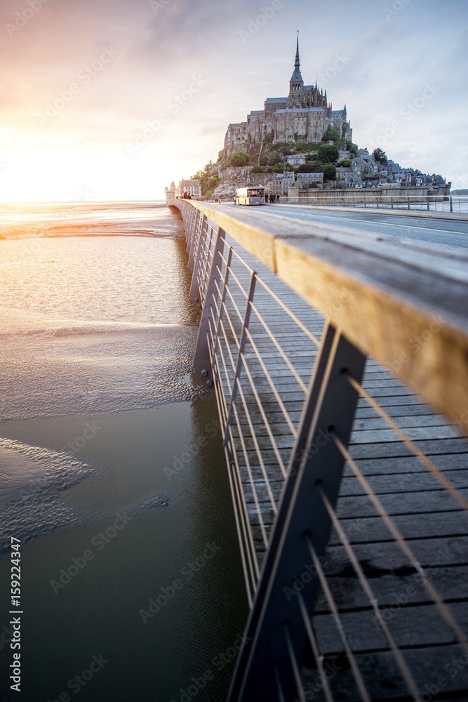 Sunset view on the famous Mont Saint Michel abbey with bridge during the tide in France