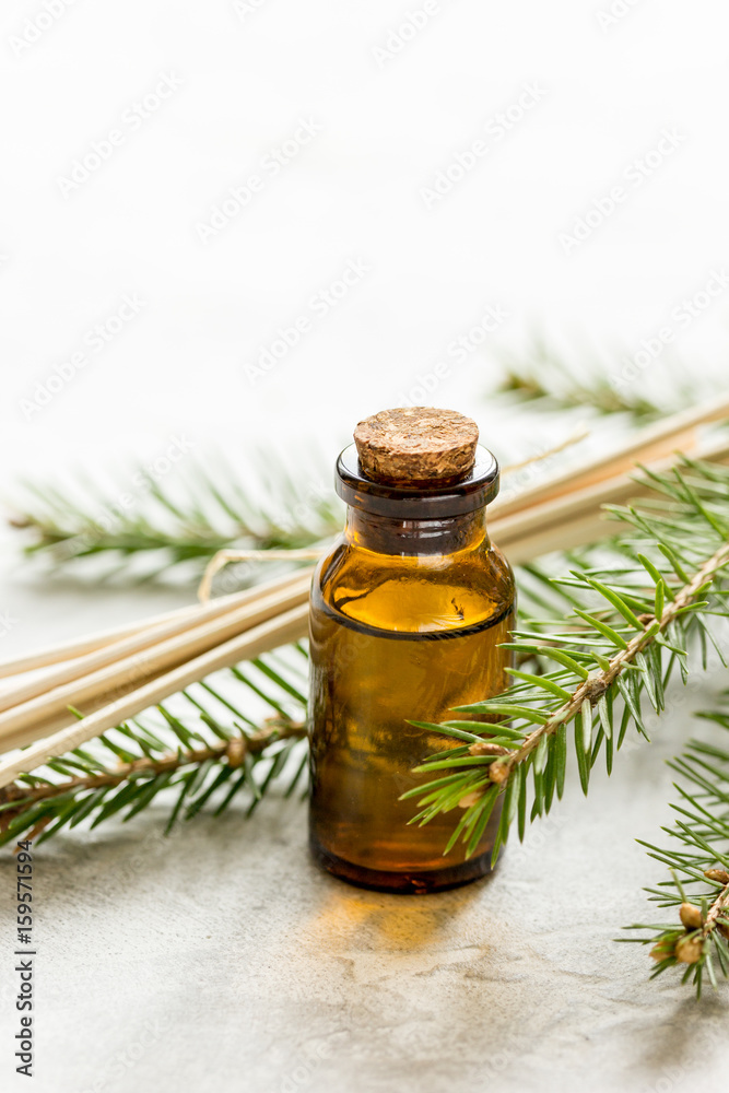 fir branches and spruce aroma oil on white table background