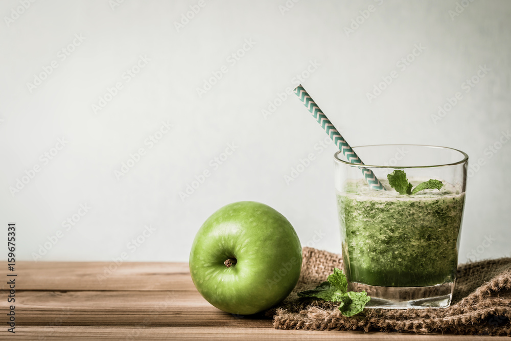 Healthy fresh  green smoothie juice in the glass bottle on wooden table for healthy detox and diet  