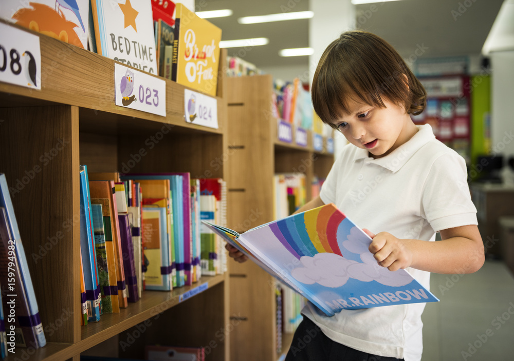 小男孩在图书馆阅读儿童故事书