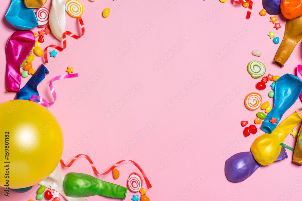庆祝平躺。粉红色背景上有五颜六色派对物品的糖果。