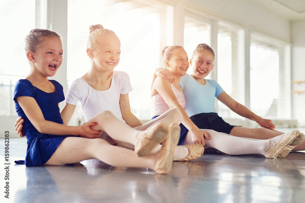 微笑的女孩在芭蕾舞课的地板上玩得很开心