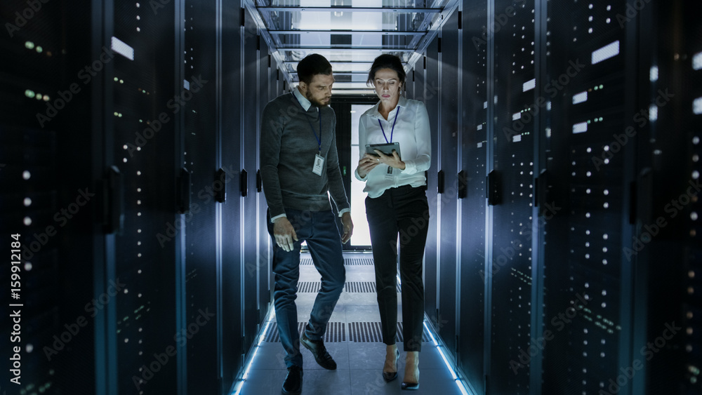 Male and Female Server Technicians Working in Data Center. Running Rack Server Diagnostics. Woman Us