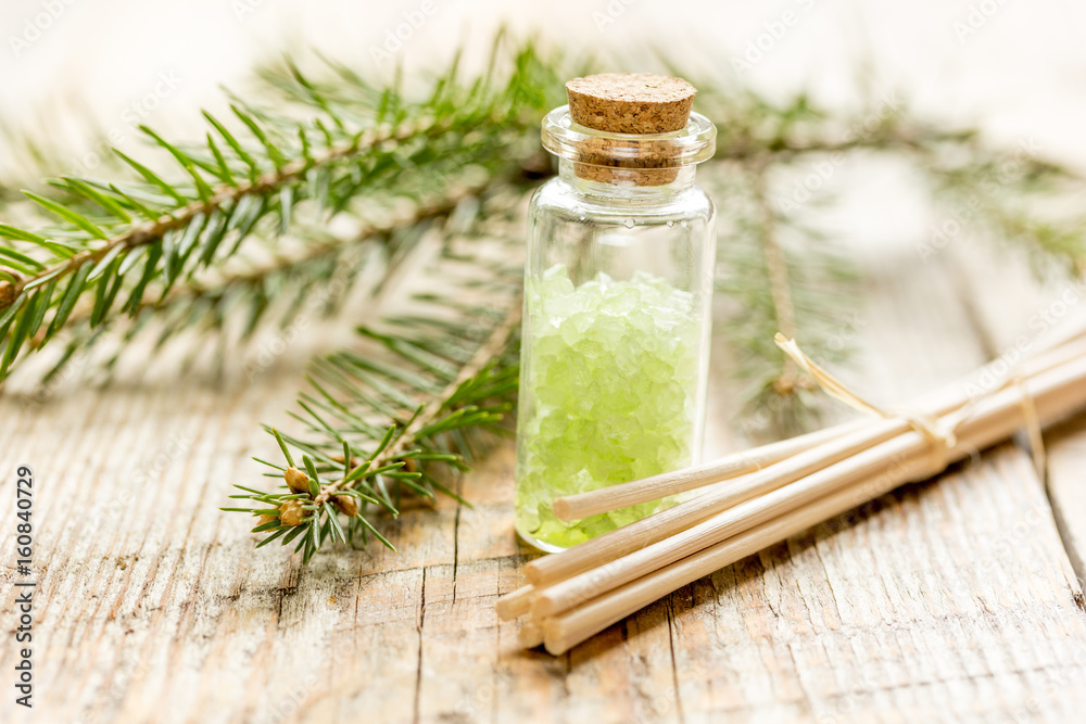 木桌背景上用于芳香疗法和水疗的海盐和冷杉枝瓶