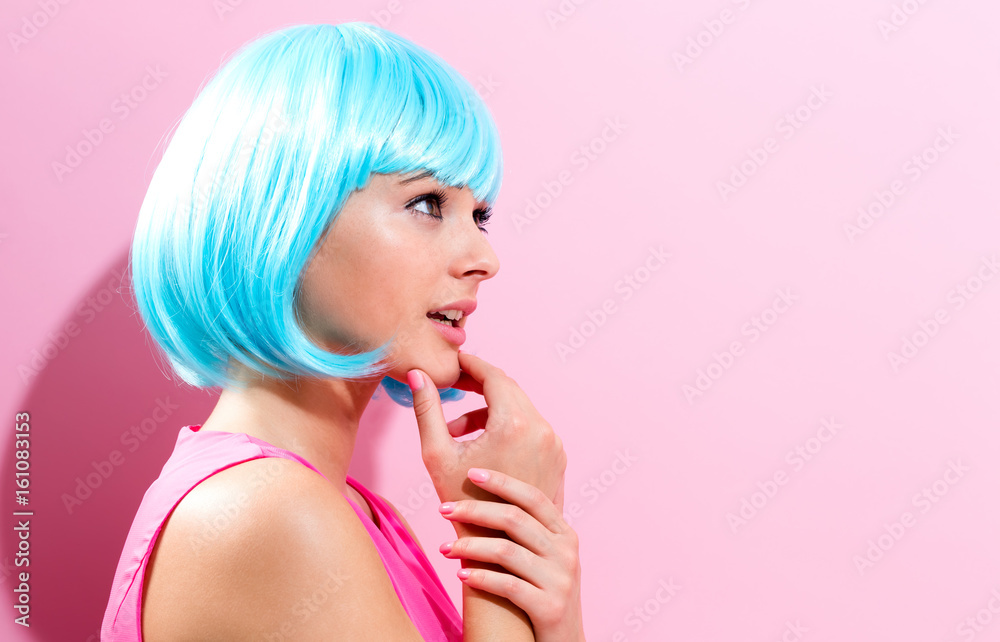粉色背景下戴亮蓝色假发的女性肖像