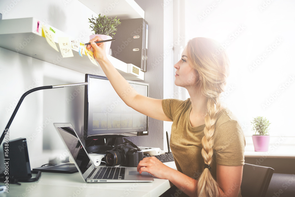 在家办公室用电脑做笔记的女人