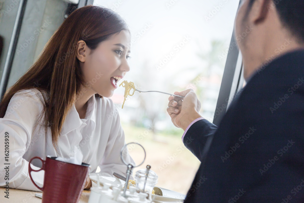 asian couple eating and laugh with love together at restaurant