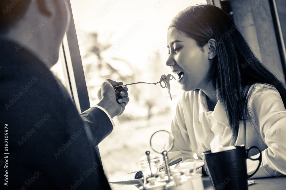 亚洲情侣在餐厅共进晚餐，开怀大笑