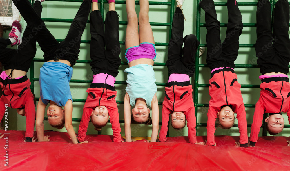 运动型儿童在健身房做倒立姿势