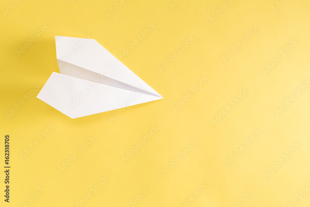 亮黄色背景的纸飞机
