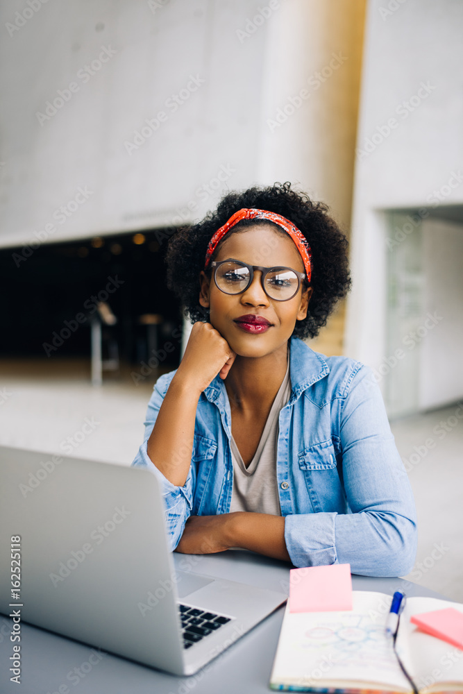 微笑的年轻非洲女企业家在她的事业上工作