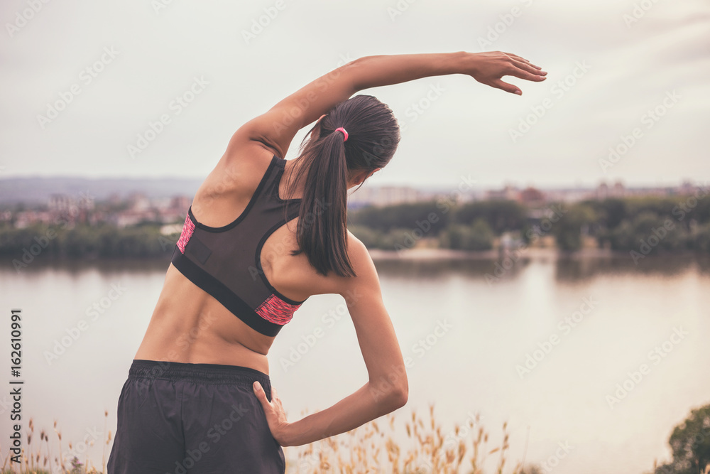 Woman stretching and exercising outdoor.