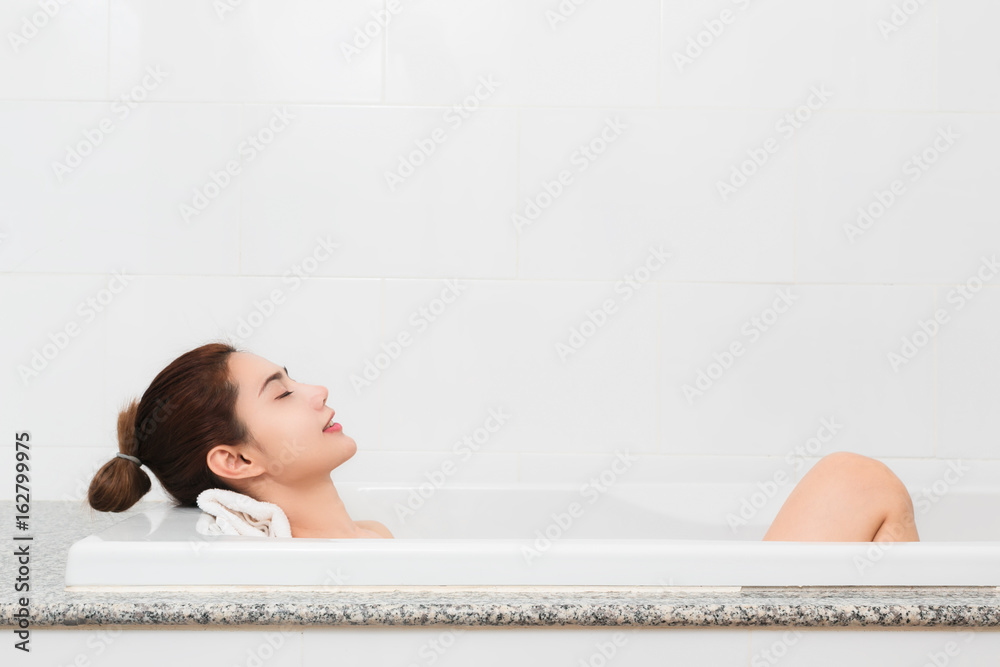 放松一下。满足于美丽的年轻女子在洗澡时放松。