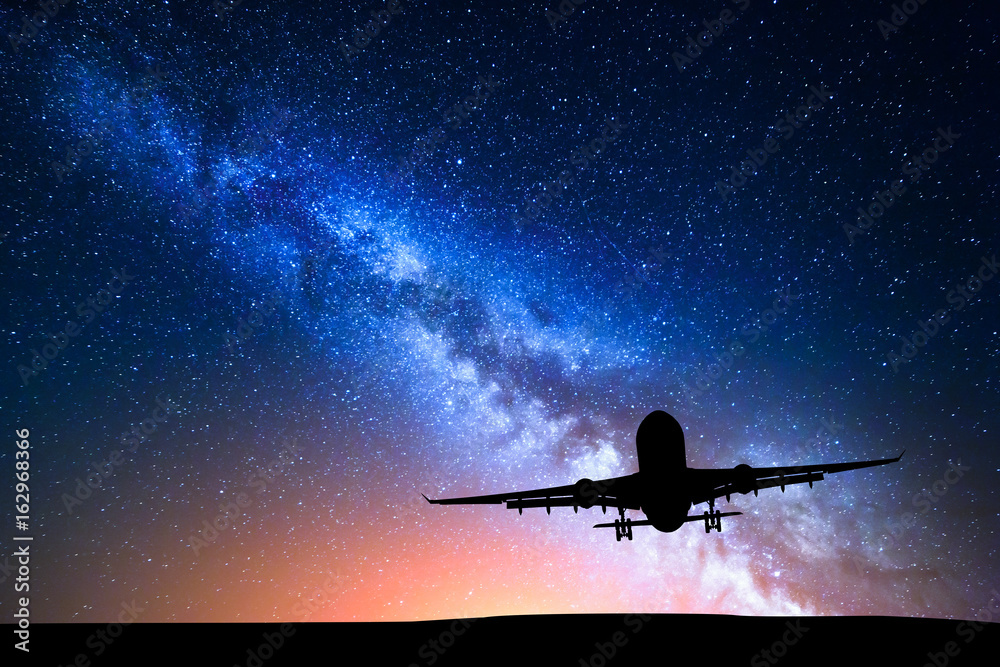 银河系和飞机的轮廓。客机在星空中飞行的风景