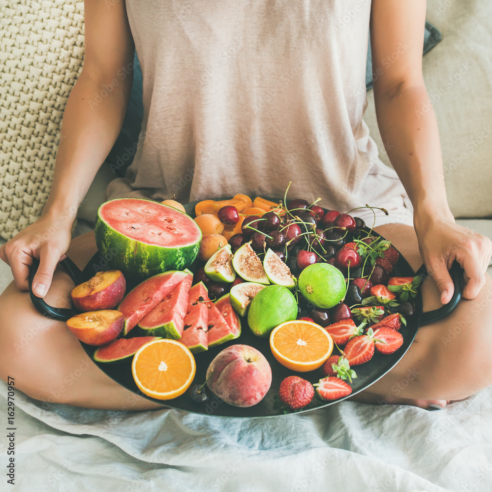 Summer healthy raw vegan clean eating breakfast in bed concept. Young girl wearing pastel colored ho