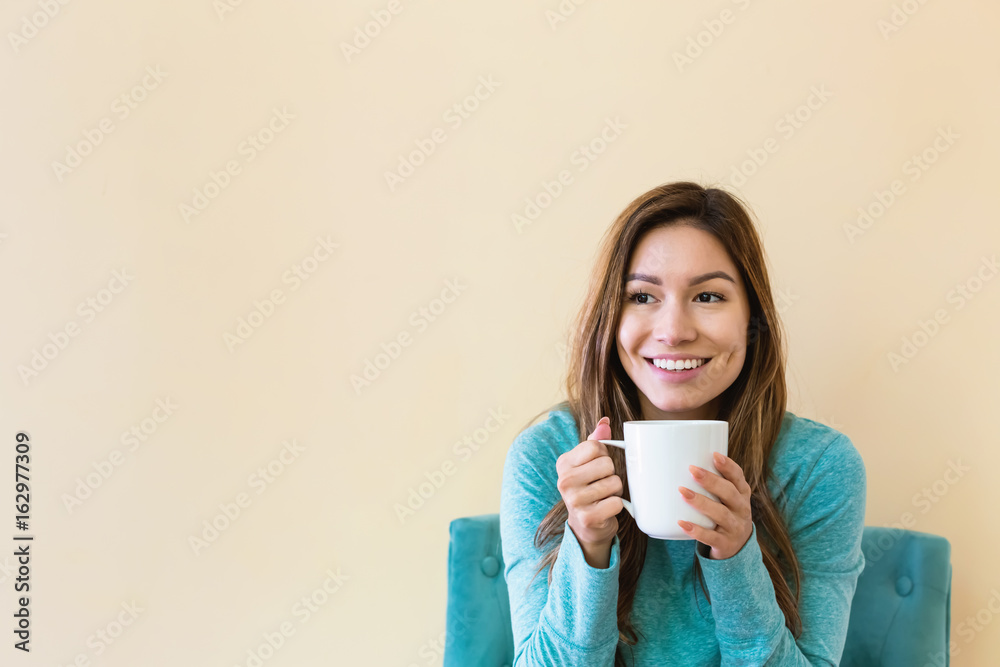 年轻的拉丁女人坐着喝咖啡