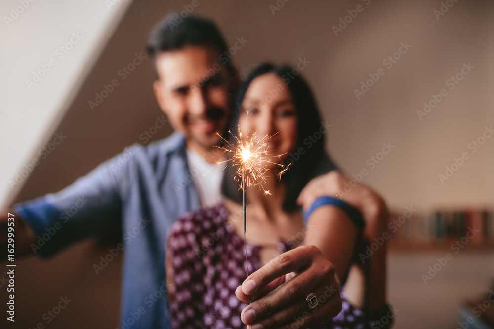 一对年轻夫妇在家用焰火庆祝