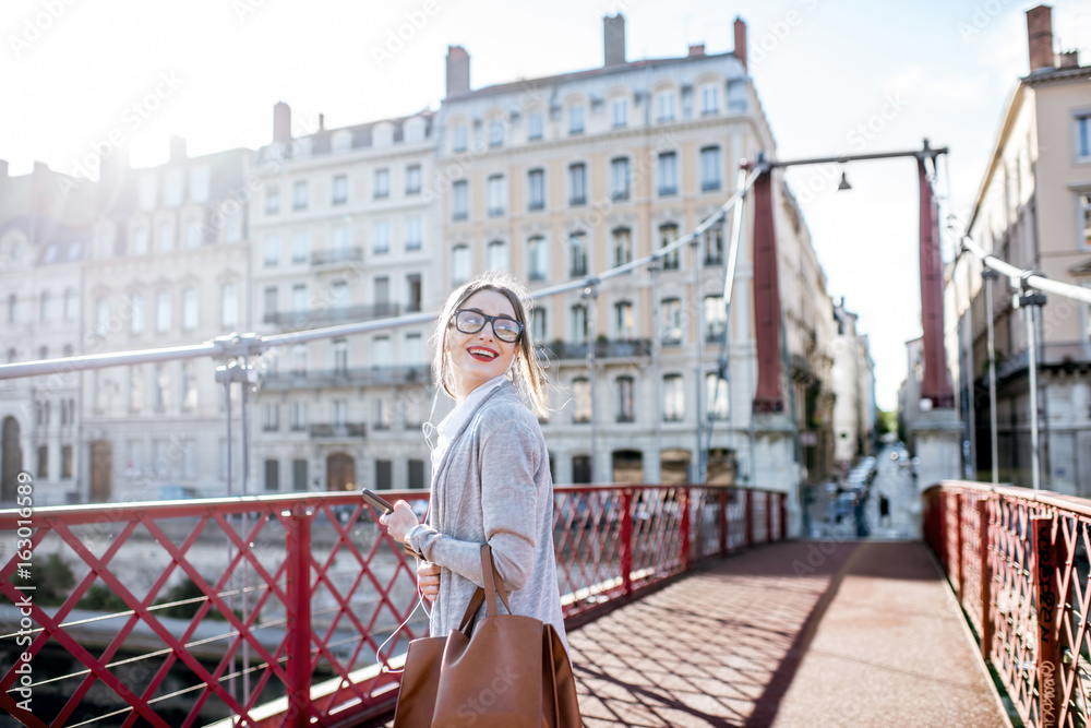 一位时尚女商人在里昂老城红桥上行走的生活方式肖像