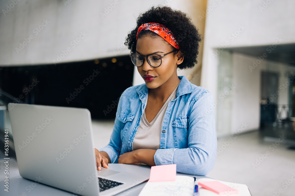 年轻的非洲女企业家在笔记本电脑上努力工作