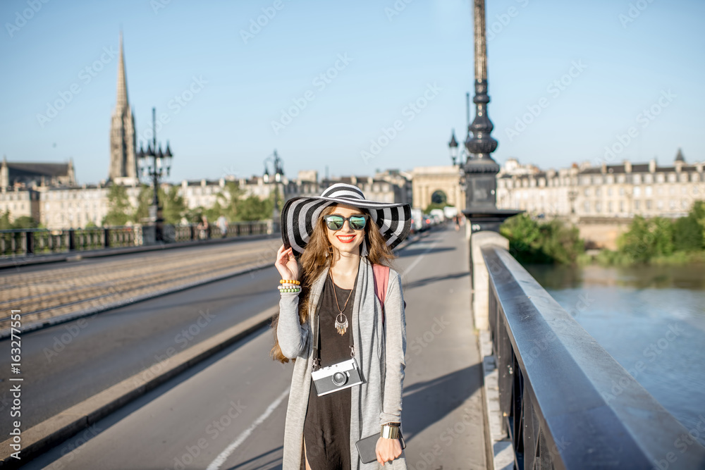 走在法国博雷道市著名的皮埃尔大桥上的年轻女游客