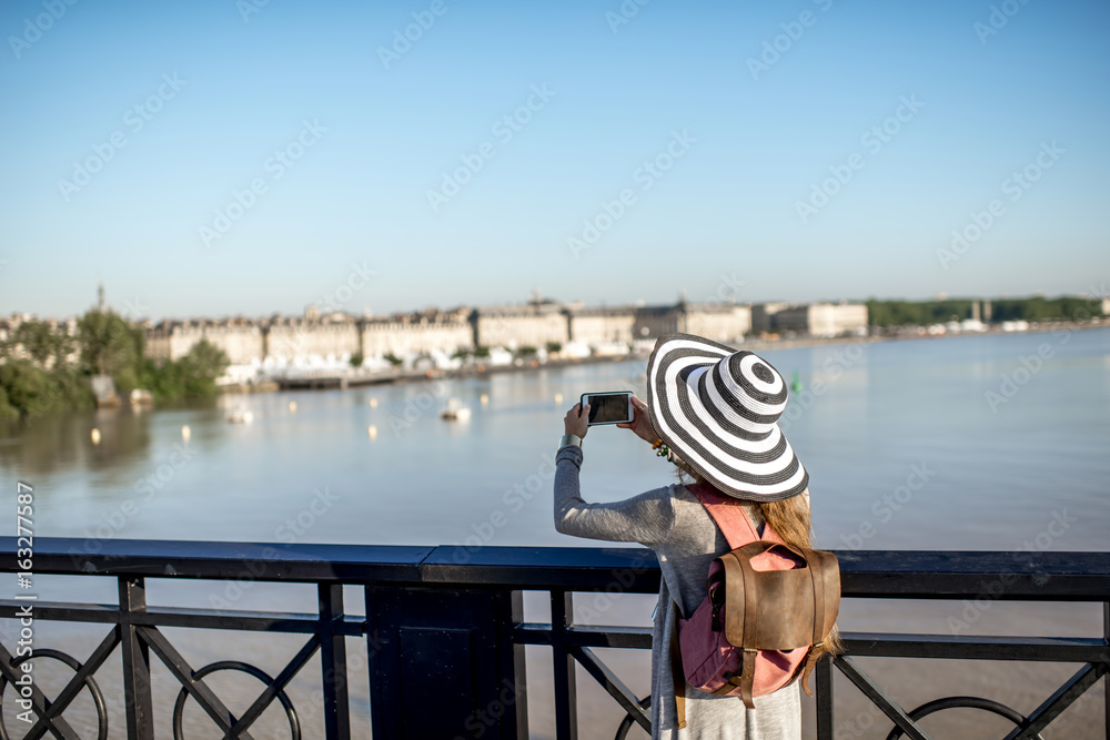 年轻的女游客站在Boredaux著名的Pierre桥上欣赏城市美景
