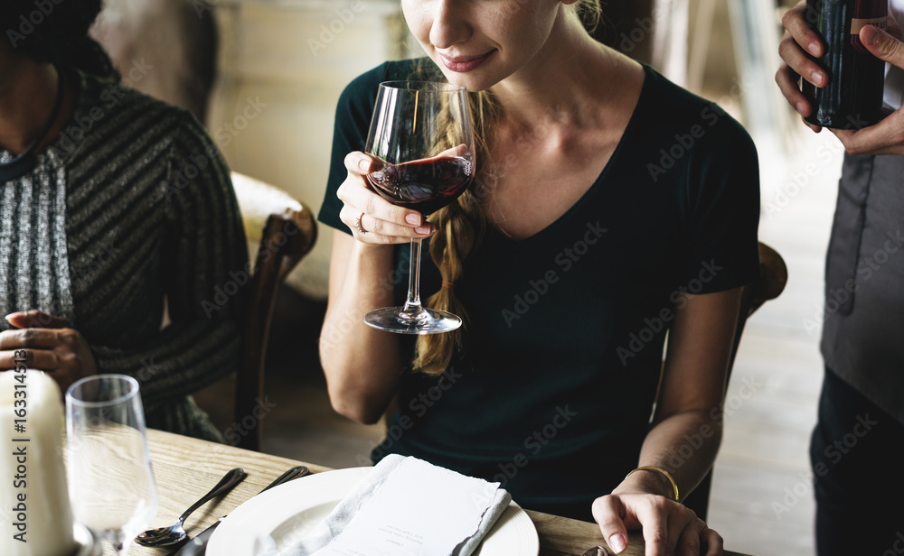 女人在优雅的餐厅品尝红酒