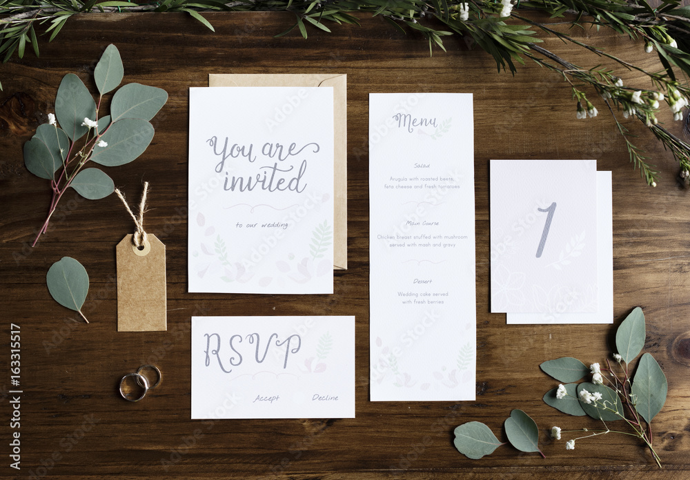 用树叶装饰桌子上的结婚邀请卡纸