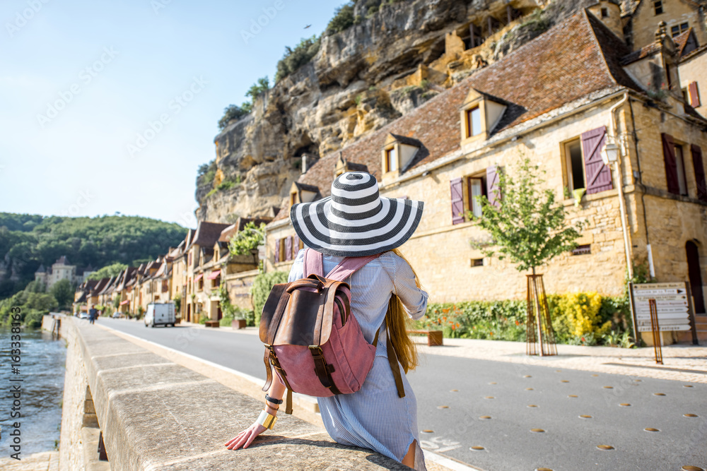 年轻的女游客在法国La Roque Gageac村欣赏古老建筑的美景