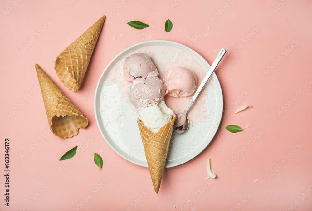 淡粉色草莓和椰子冰淇淋勺，白色盘子上的甜华夫饼蛋卷