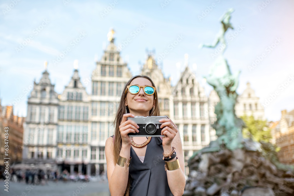 年安特卫普大市场广场上一位年轻女游客的肖像，带着相机