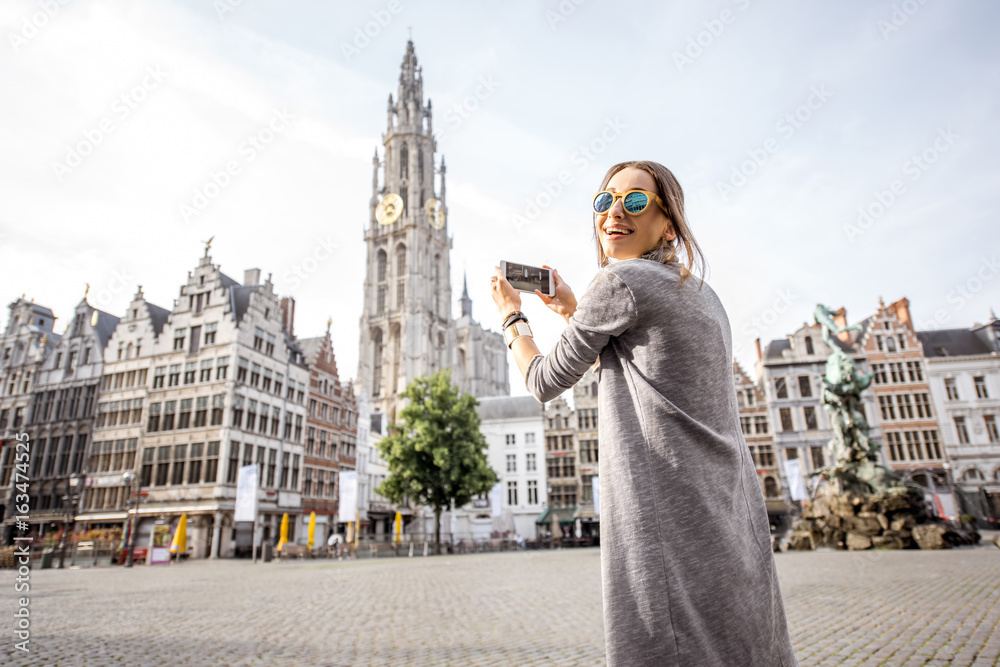 年轻女性游客用手机拍摄矗立在大市场广场上的著名大教堂
