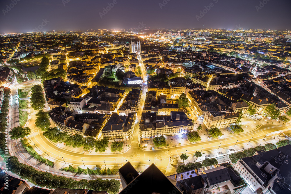 Aerial cityscape view with illuminated buildings and streets in Nantes city during the night in Fran