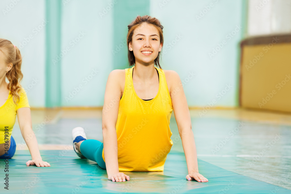 美丽的亚洲女孩在体育馆里伸展身体