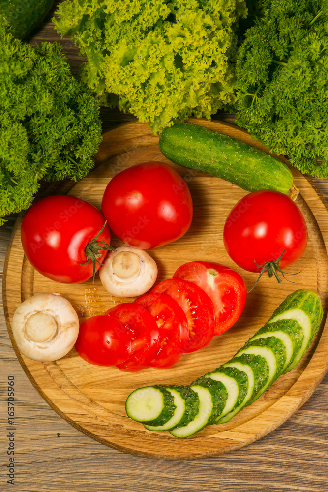 新鲜蔬菜。木板上的西红柿、黄瓜和蘑菇