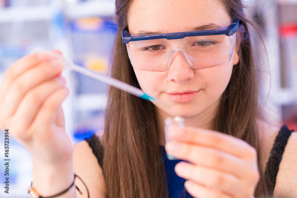A teenage girl in a school laboratory in chemistry and biology classes
