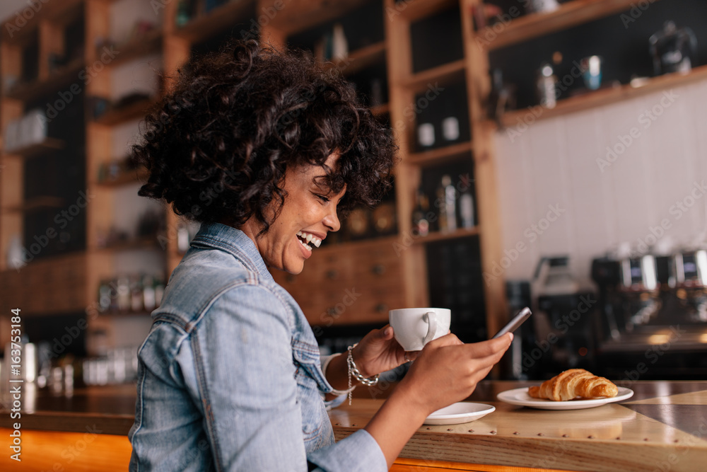 非洲女人咖啡馆用手机微笑