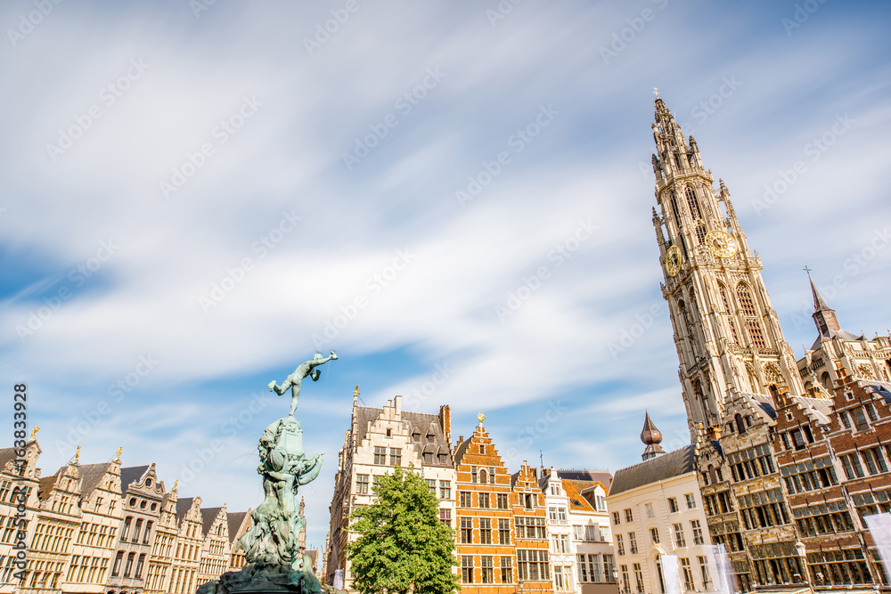 View on the beautiful buildings with fountain sculpture and church tower in the center of Antwerpen 